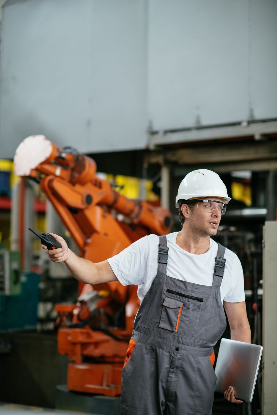 Worker in a hard hat assessing equipment on a plant floor